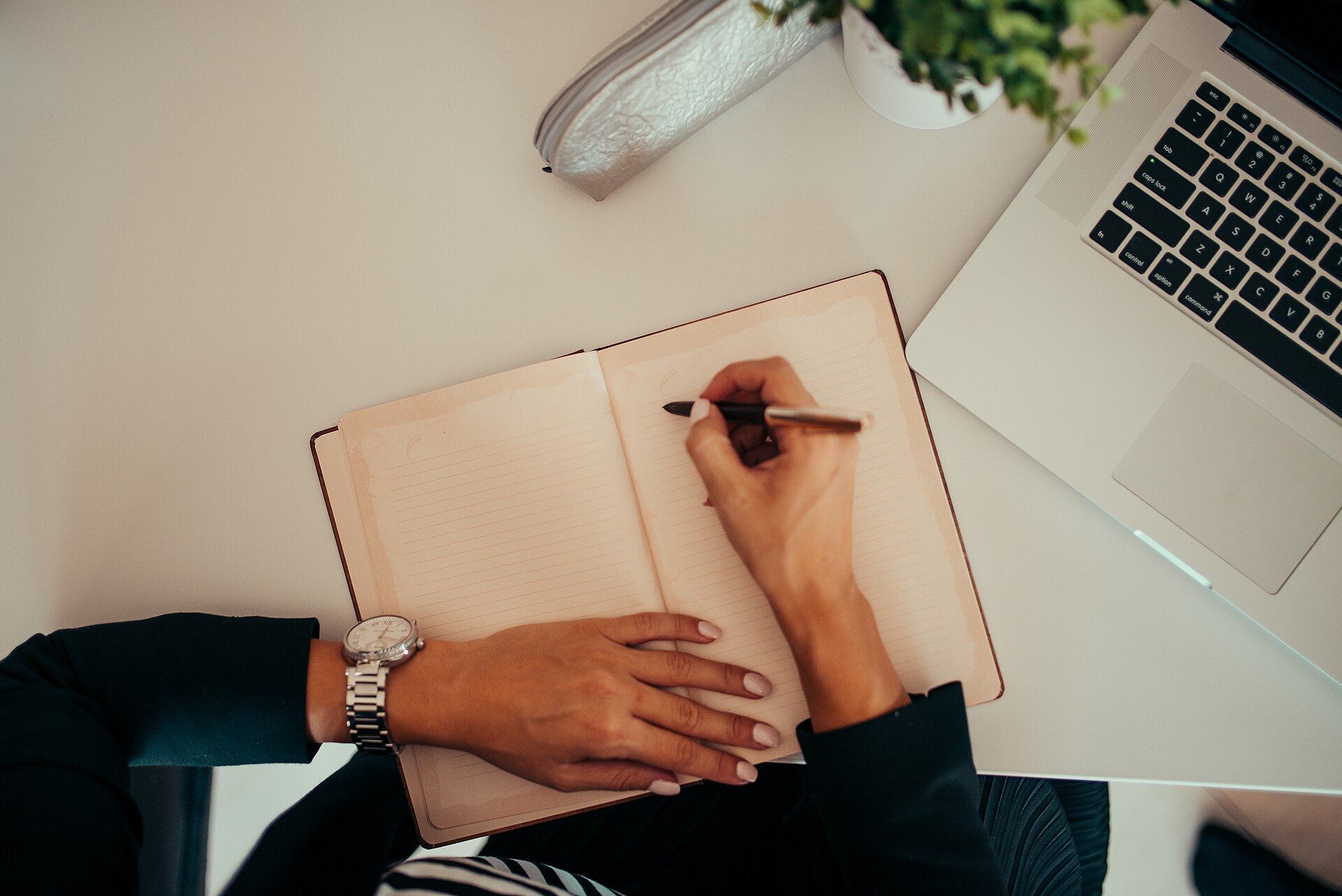 Affiliate marketer writing a product review at a laptop with handwritten notes