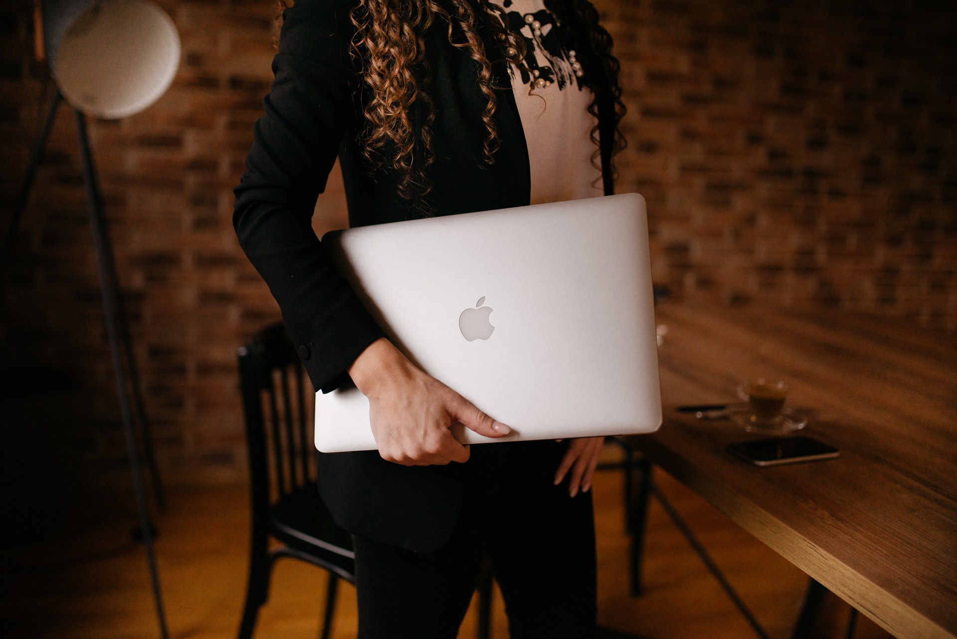 Young business woman holding a laptop in her home office — starting an affiliate business on Wealthy Affiliate's free Starter plan