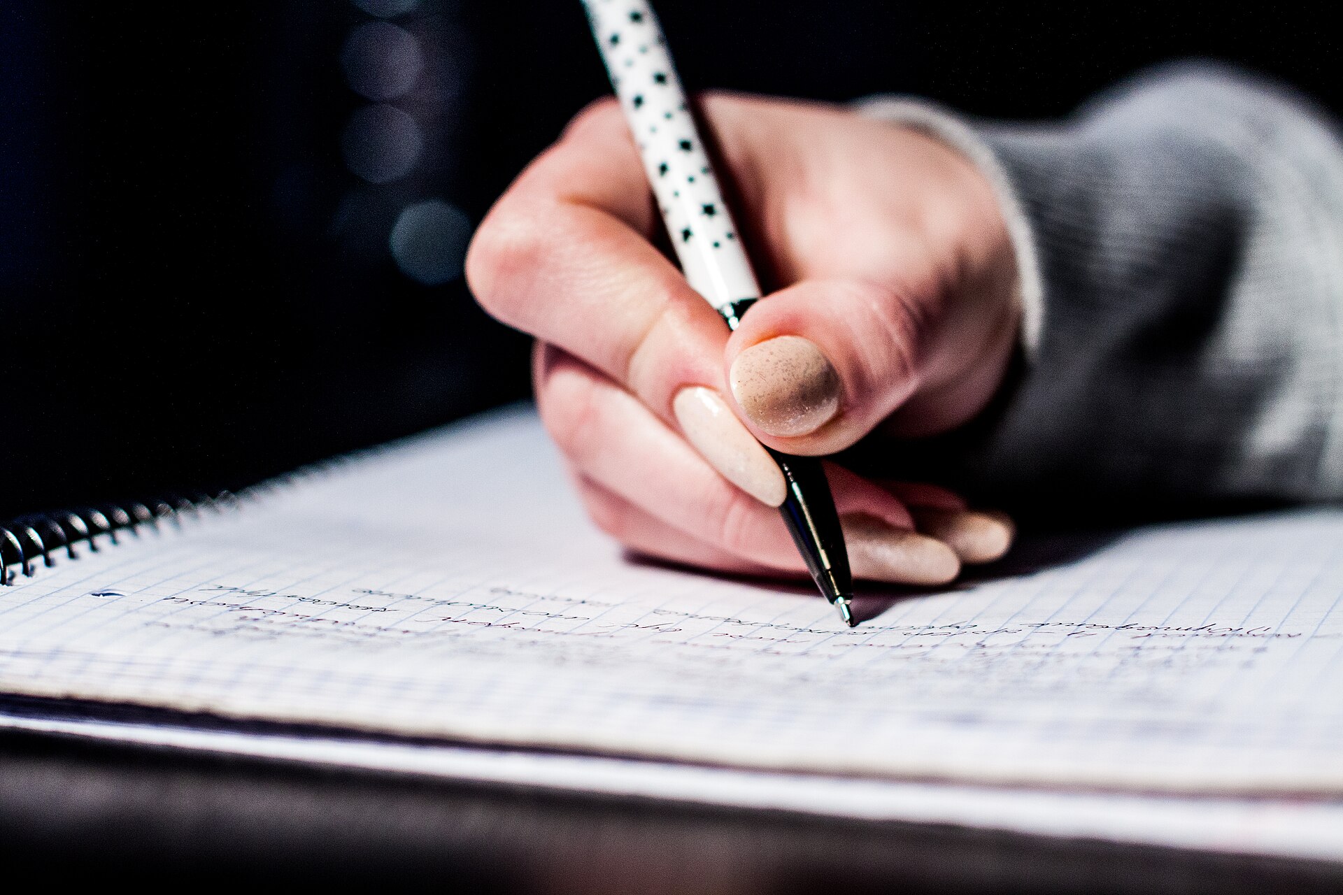 Hand writing review notes with a pen during hands-on product testing