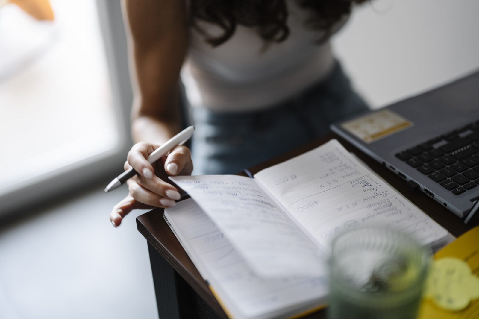 A person planning article ideas in a notebook at a desk