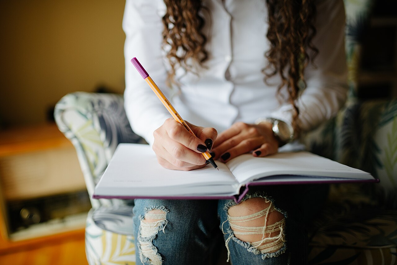 Hands writing notes in a planner, close up