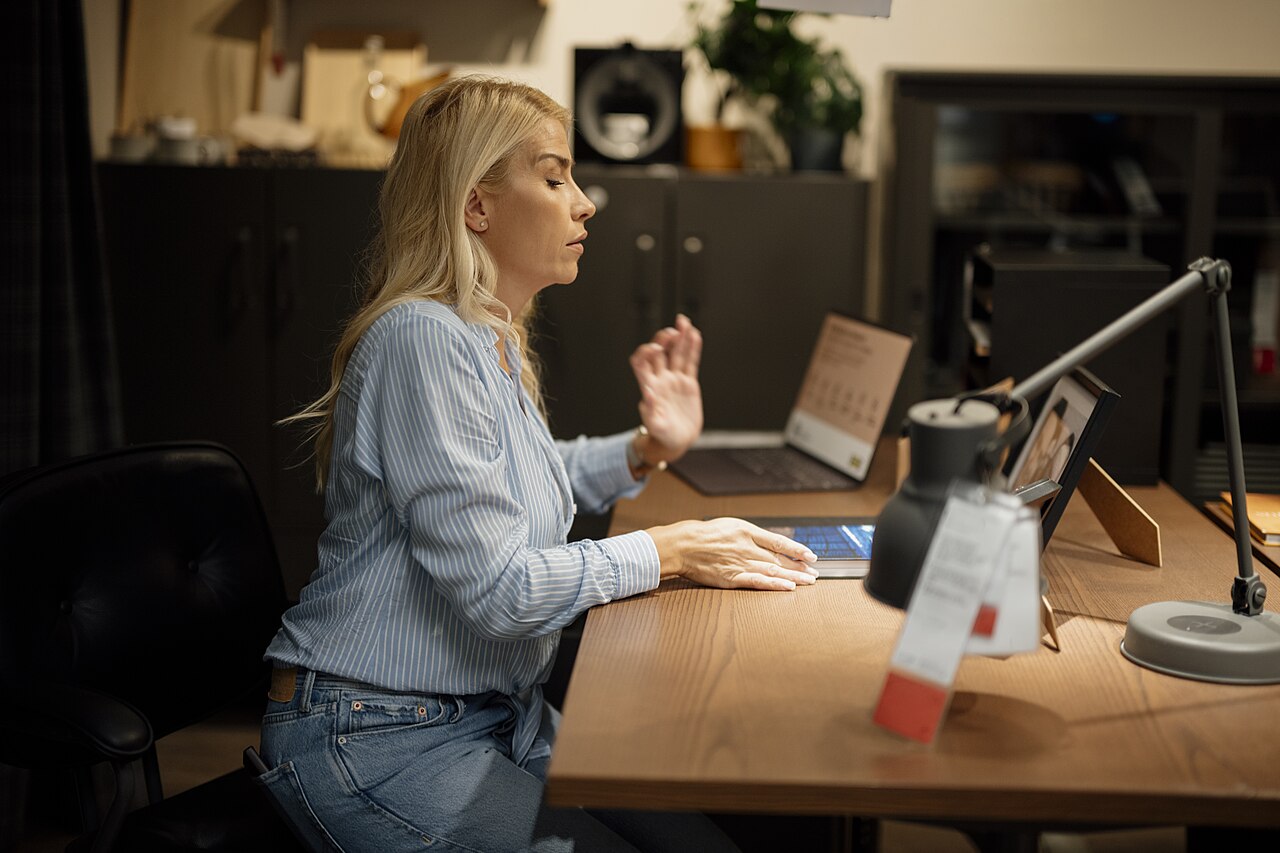 Woman working on a laptop at a desk in a home office