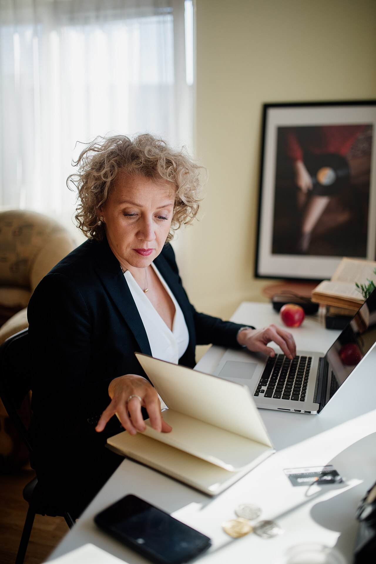 Woman working at a desk with a laptop and documents