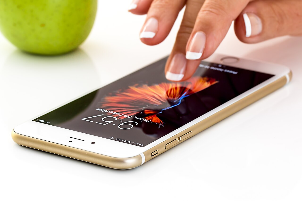 Hand about to tap a smartphone screen, illustrating social media content creation